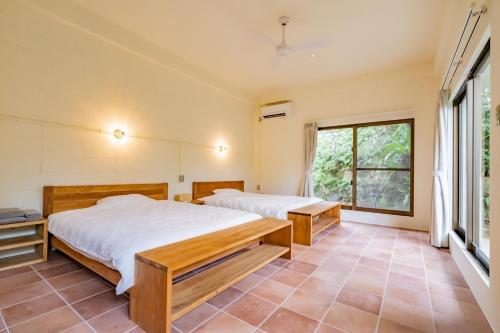 1 dormitorio con 2 camas y ventana grande en Cape Maeda FLAT - Vacation STAY 14596, en Yamada