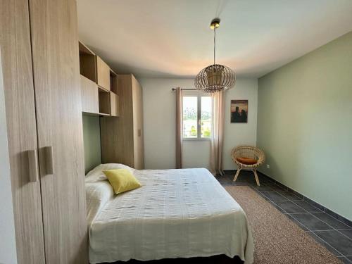 Schlafzimmer mit einem Bett und einem Kronleuchter in der Unterkunft Maison avec piscine et vue sur les collines. in Marseille