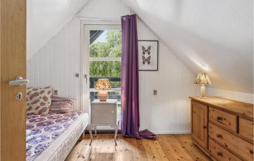 Schlafzimmer mit einem Bett und einem Fenster mit lila Vorhängen in der Unterkunft Cozy Home In Nykbing Sj With Kitchen in Klint