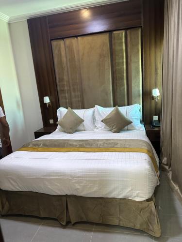 a bedroom with a large bed with a wooden headboard at الاتحاد الذهبية للشقق المخدومة 3 in Al Hofuf