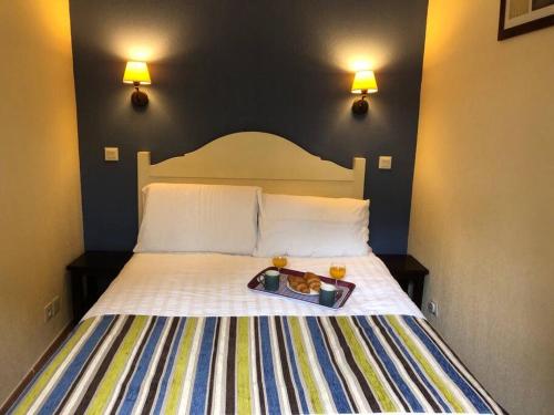 Una cama en una habitación de hotel con una bandeja de comida. en appartement T3 Soustons plage Vieux Boucau océan, en Soustons