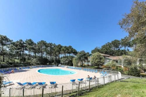 una piscina con sillas azules y una valla en appartement T3 Soustons plage Vieux Boucau océan, en Soustons