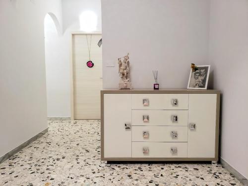 a dresser in a room with a white wall at Dimora Prezioso - Affitti Brevi Italia in Monte SantʼAngelo