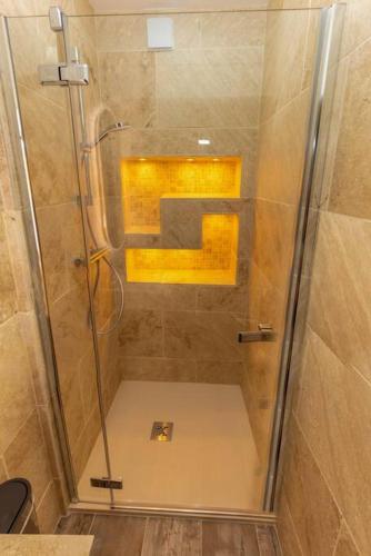 a shower with a glass door in a bathroom at Le papillon in Aubenas