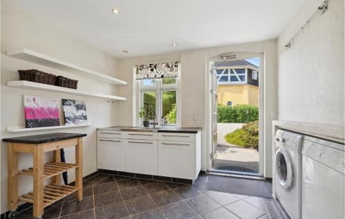 a white kitchen with a washer and dryer at 4 Bedroom Nice Home In Nyborg in Nyborg