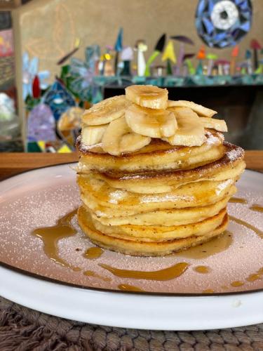 a stack of pancakes with bananas on top on a plate at Casa Chuparrosas in San Mateo Río Hondo