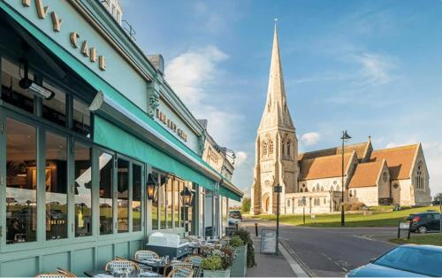 een stad met een kerk en een straat met een gebouw bij Beautiful 5-bedroom private house in quiet London street 2 minutes from station in Londen