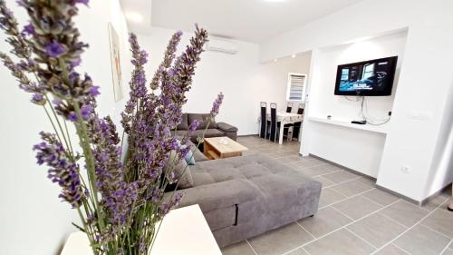 a living room with a couch and purple flowers at Tonka in Vodice
