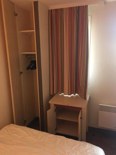 - une chambre avec un lit, un bureau et un rideau dans l'établissement P2 VILLAGE CLUB CAP ESTEREL Vue Golf et Mer, Piscine Chauffée, à Saint-Raphaël