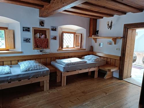 two beds in a room with wooden floors and windows at Pr Močnk in Bled