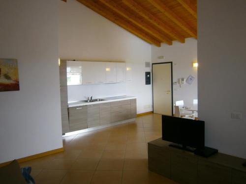 uma grande cozinha com um lavatório e uma televisão em Villaggio Sant'Andrea em Caorle