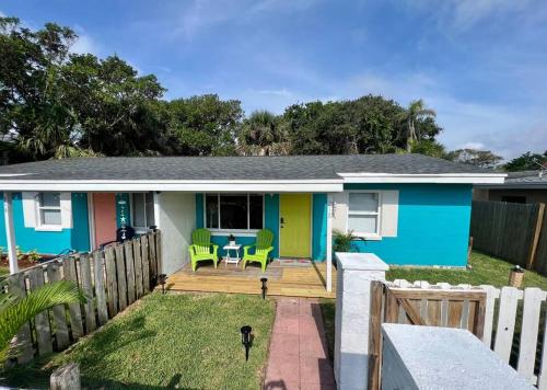 a blue house with a deck with green chairs at Palm Paradise in downtown Cocoa Beach in Cocoa Beach