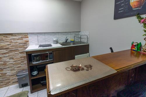 a kitchen with a table and a sink and a counter at Delcafetalcr in San José