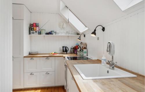 eine Küche mit weißen Schränken und einem Waschbecken in der Unterkunft Cozy Home In Nykbing Sj With Kitchen in Klint