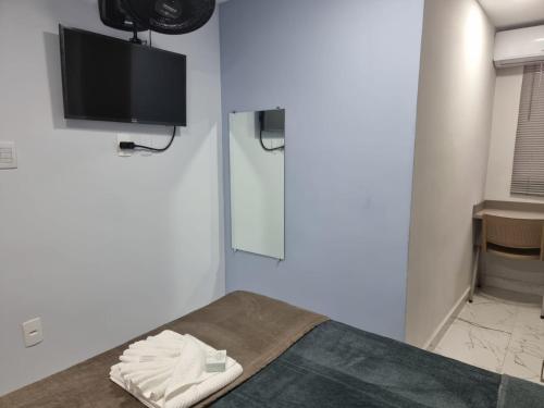 um quarto com uma cama e uma televisão de ecrã plano em Loft no Cond. Mata Atlântica em Volta Redonda