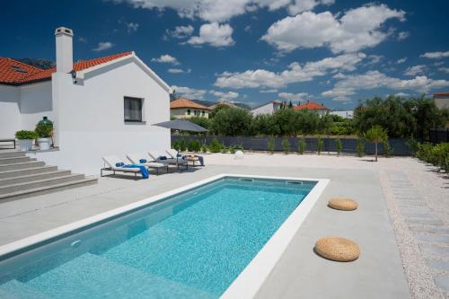 une piscine devant une villa dans l'établissement Villa Activitas - Professional Fitness & Pool, à Kaštela