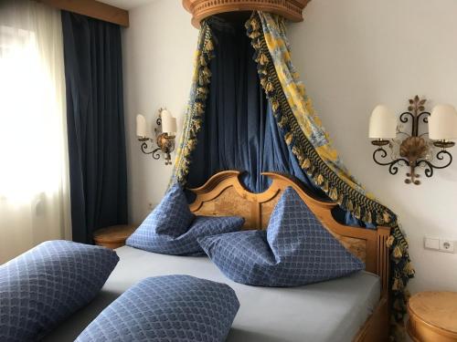 een slaapkamer met een hemelbed met blauwe kussens bij Haus Aida in Längenfeld