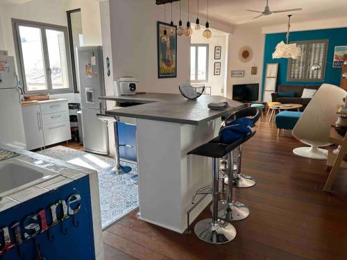 une cuisine et un salon avec un comptoir et des chaises dans l'établissement Loft 80m2 Bandol dernier étage à 100m plage, centre, port, à Bandol