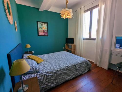 - une chambre avec un lit et un mur bleu dans l'établissement Loft 80m2 Bandol dernier étage à 100m plage, centre, port, à Bandol