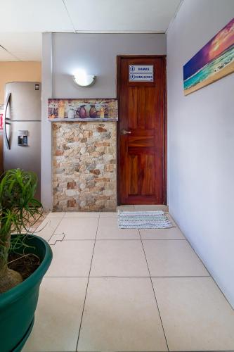 a hallway with a wooden door and a tile floor at Delcafetalcr in San José