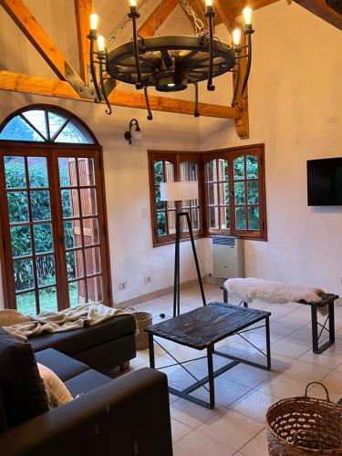 ein Wohnzimmer mit Sofa und Tisch in der Unterkunft La casita de LOS CERROS DE SMA in San Martín de los Andes
