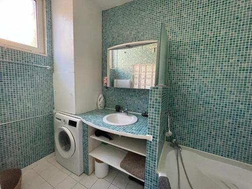 une salle de bain avec un lavabo et une machine à laver dans l'établissement Duplex Montpellier centre-ville, à Montpellier