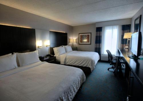 a hotel room with two beds and a flat screen tv at Holiday Inn Express Janesville-I-90 & US Highway 14, an IHG Hotel in Janesville