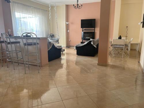 a living room with a tiled floor and a table and chairs at Delphitea Philoxenia in Itea