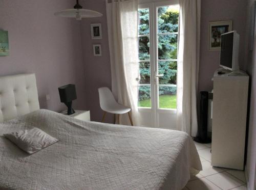 une chambre avec un lit blanc et une fenêtre dans l'établissement VILLA MIREILLE CALME ARBOREE PISCINE SANS VIS A VIS SECURISEE, à Morières-lès-Avignon