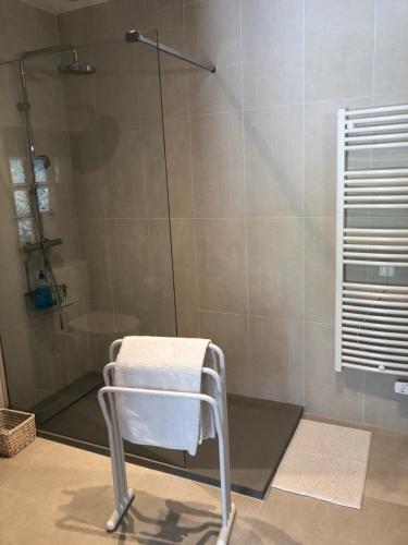 een douche met een handdoek op een stoel in de badkamer bij Mougere des oliviers in Galargues