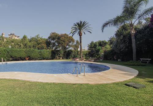 una piscina en un patio con palmeras en Palm House en Marbella