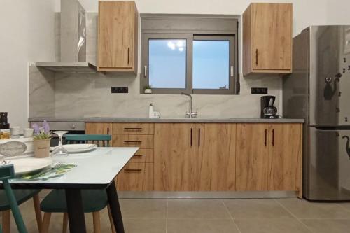 ソウダにあるDream House Soudaのキッチン(木製キャビネット、テーブル、冷蔵庫付)