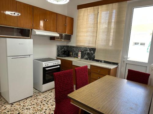 a kitchen with a table and a white refrigerator at Goldy Centre Home in Rethymno Town