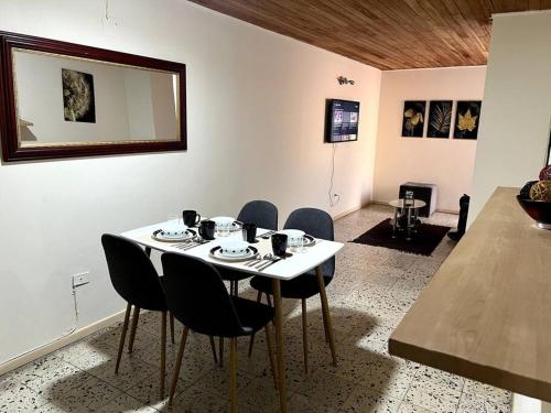 a dining room with a white table and chairs at hermoso y amplio apartamento con desayuno incluido in Medellín