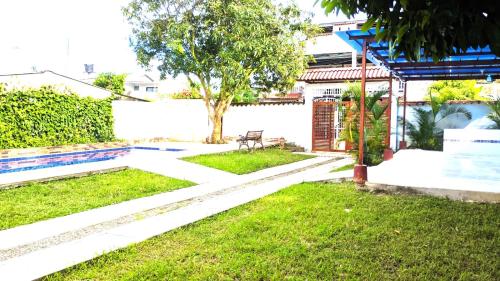 a garden with a bench and a tree at Casa de descanso acacias meta in Acacías