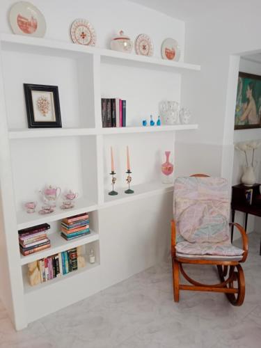 a chair in a room with white shelves at La casa blanca in La Pineda