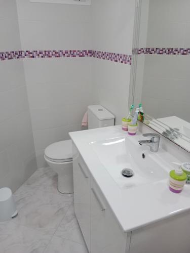 a white bathroom with a sink and a toilet at La casa blanca in La Pineda