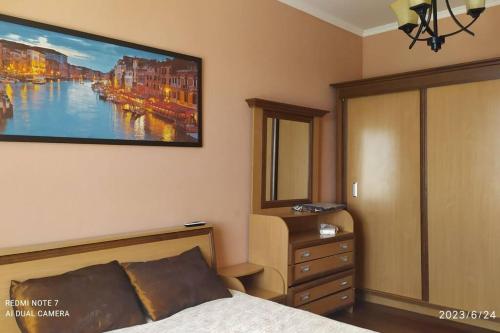 a bedroom with a bed and a painting on the wall at Elegant Condo next to Bazaar, close to the metro station, 9 in Tashkent