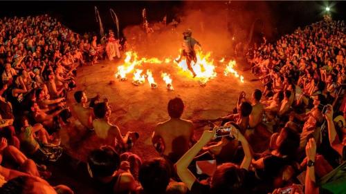 an audience watching a man in a ring of fire at Baruna Sari Villa in Ubud