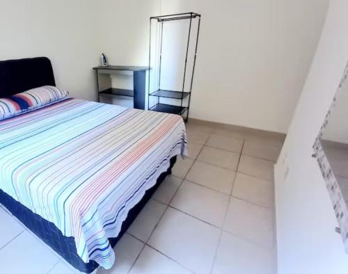 a bedroom with a bed with a mirror and a table at Apto 2Q Wifi Garagem Shopping in Taubaté