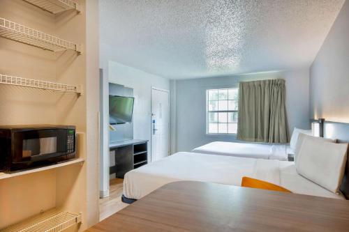 Cette chambre comprend 2 lits et une télévision. dans l'établissement Studio 6-San Antonio, TX - Medical Center, à San Antonio