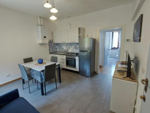 a kitchen with a table and a stainless steel refrigerator at La Casa di Erika - Pesaro Centro-Mare in Pesaro
