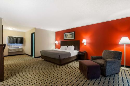 a hotel room with a bed and a chair at Quality Inn & Suites Millville in Millville