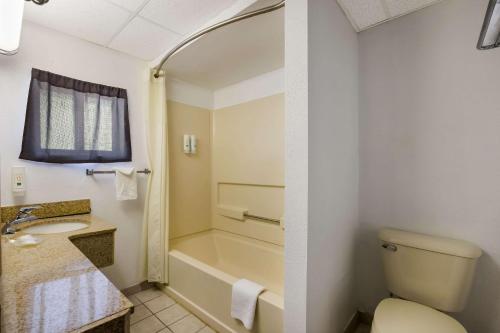 een badkamer met een bad, een toilet en een wastafel bij Quality Inn & Suites Millville in Millville