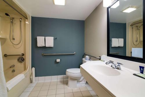 ein Badezimmer mit einem Waschbecken, einem WC und einem Spiegel in der Unterkunft Sleep Inn Londonderry in Londonderry