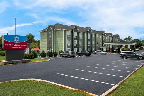 a building with cars parked in a parking lot at SureStay Plus Hotel by Best Western Sevierville in Sevierville