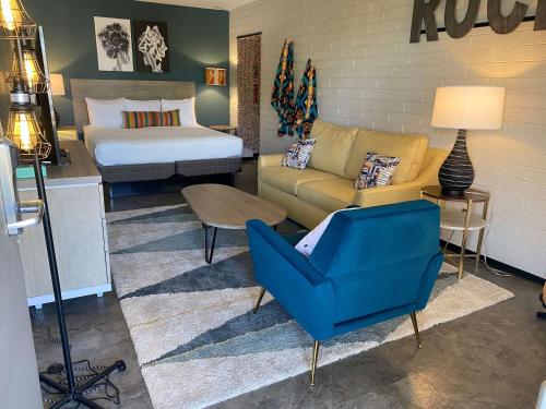 sypialnia z łóżkiem, niebieskim krzesłem i kanapą w obiekcie Egyptian Motor Hotel BW Signature Collection w mieście Phoenix