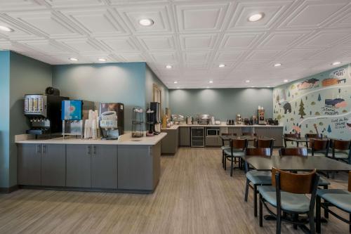 a waiting room with tables and chairs in a restaurant at SureStay Plus Hotel by Best Western Sevierville in Sevierville