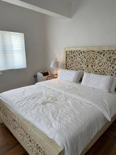 a bedroom with a large white bed with a wooden headboard at Dar Sayang in Taif