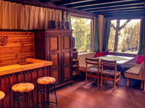 ゾンネンアルペ・ナスフェルトにあるWurzer Ferienhütteのテーブルと椅子、窓が備わる客室です。